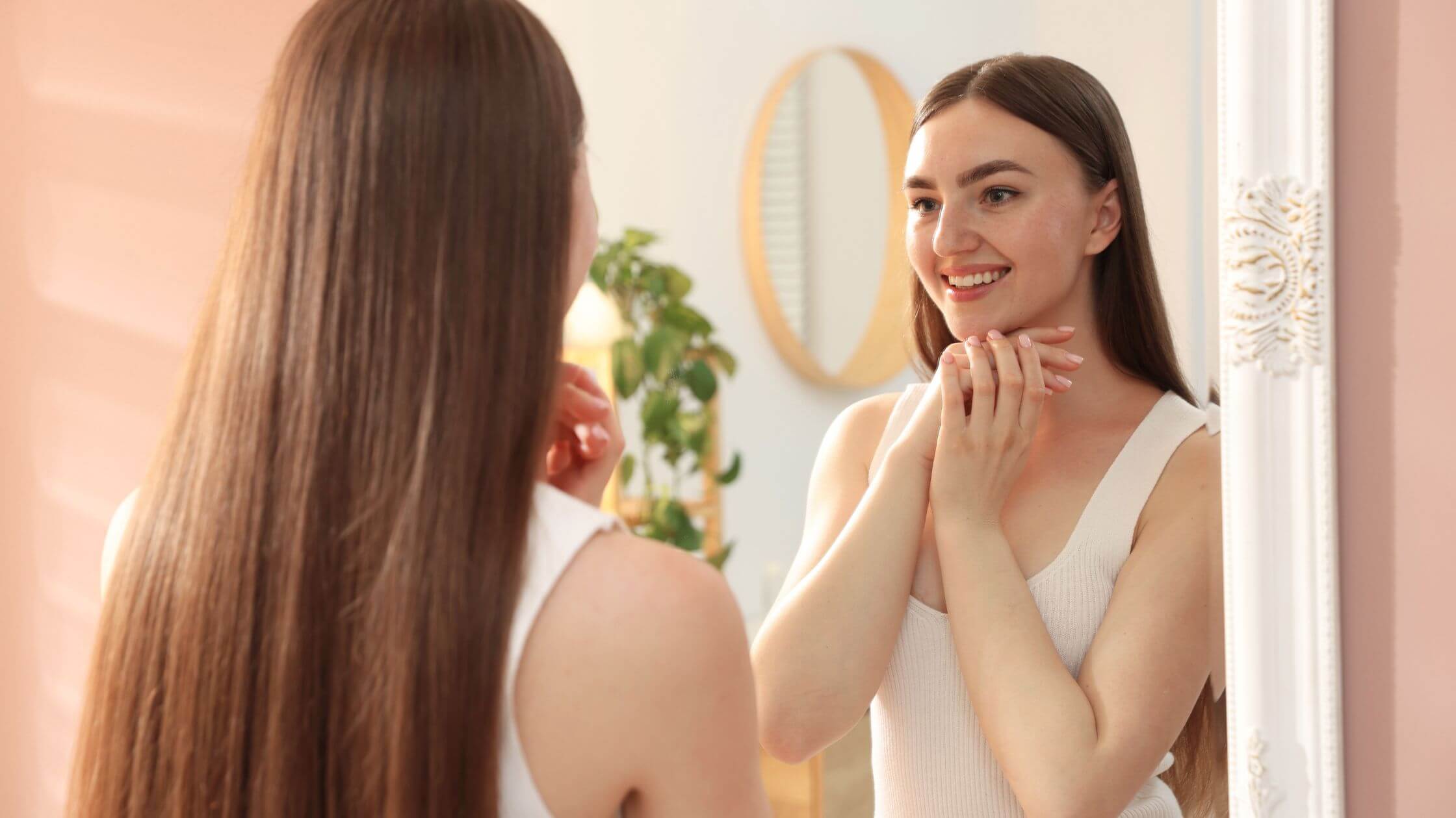 Persona observando su sonrisa y cuidando su salud oral mediante la hidratación