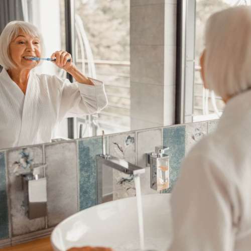 Persona revisando su sonrisa después de cepillarse los dientes
