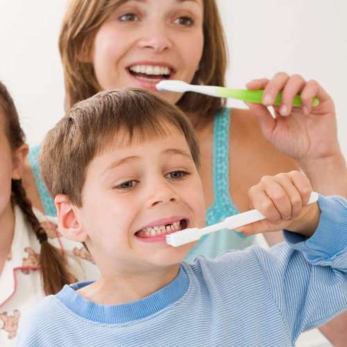 Persona realizando una rutina completa de higiene oral frente al espejo.
