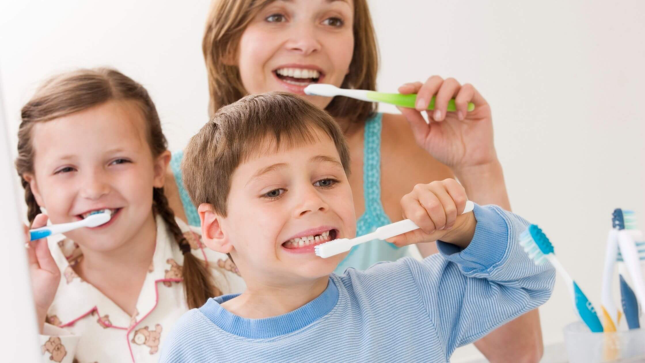 Persona realizando una rutina completa de higiene oral frente al espejo.
