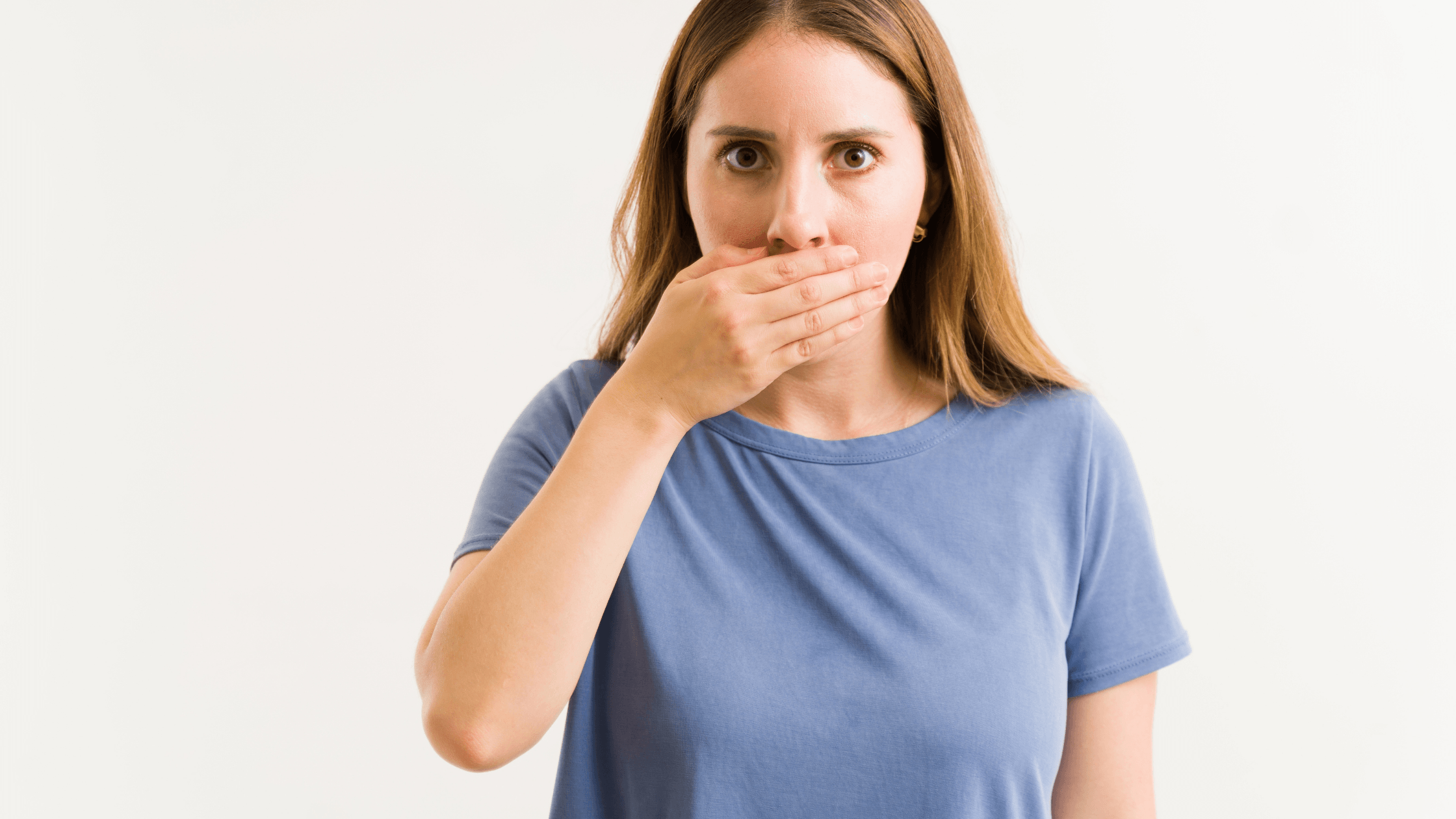 Persona preocupada por tener mal aliento a pesar de cepillarse los dientes